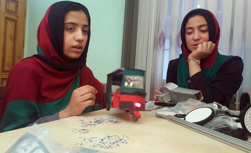 Teenage girl Sumaya Farooqi, 14, left, from Afghanistan Robotic House, a private training institute, practices with her colleagues at the Better Idea Organization center in Herat,  Afghanistan, Thursday, July 6, 2017. Six female students from Afghanistan who had hoped to participate in an international robotics competition in the U.S. this month will be forced to watch via video link from their hometown in Herat province after the U.S. denied them visas. (AP Photos/Ahmad Seir)