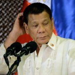 Philippine President Rodrigo Duterte scratches his head during his speech at the ceremonial turnover to the Armed Forces of the Philippines at the Malacanang presidential palace in Manila, Philippines Tuesday, July 18, 2017. Duterte asked Congress on Tuesday to extend martial law in the southern third of the country until the end of the year, saying the rebellion there will not be quelled by July 22, the end of his 60-day martial law proclamation.(AP Photo/Aaron Favila)