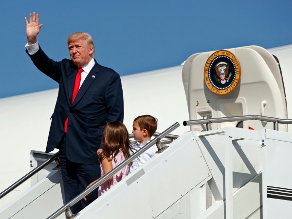 President Donald Trump waves as he walks down the steps of Air Force One with his grandchildren, Arabella Kushner, center, and Joseph Kushner, right, after arriving at Morristown Municipal Airport to begin his summer vacation at his Bedminster golf club, Friday, Aug. 4, 2017, in Morristown, N.J. (AP Photo/Evan Vucci)