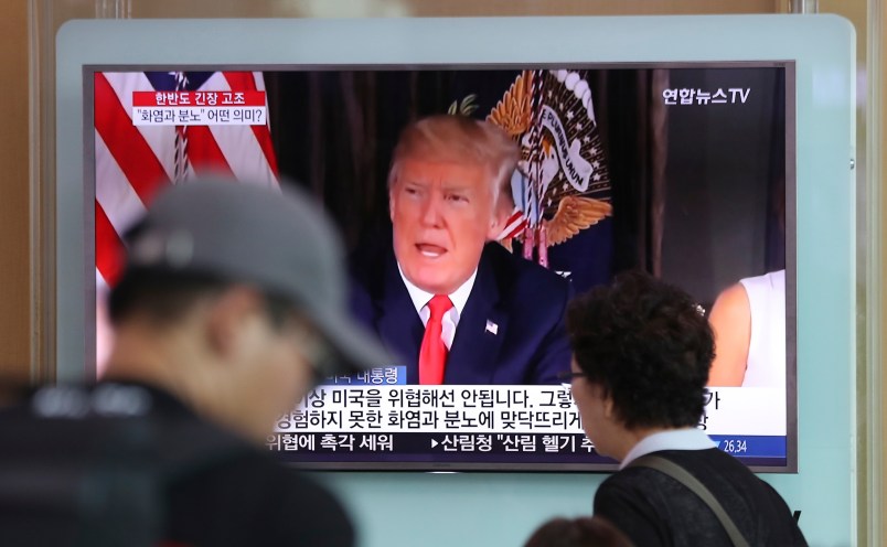 People walk by a TV screen showing a local news program reporting with an image of U.S.President Donald Trump at Seoul Train Station in Seoul, South Korea, Wednesday, Aug. 9, 2017. North Korea and the United States traded escalating threats, with President Donald Trump threatening Pyongyang "with fire and fury like the world has never seen" and the North's military claiming Wednesday it was examining its plans for attacking Guam. (AP Photo/Lee Jin-man)