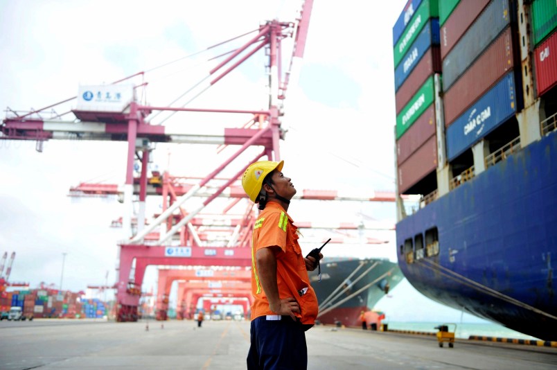 In this Tuesday, Aug. 8, 2017 photo, a worker watches as shipping containers are loaded onto a ship at a port in Qingdao in eastern China's Shandong province. China's government says it will respond to a possible trade probe ordered by President Donald Trump with "all appropriate measures" to protect Chinese interests. (Chinatopix via AP) CHINA OUT