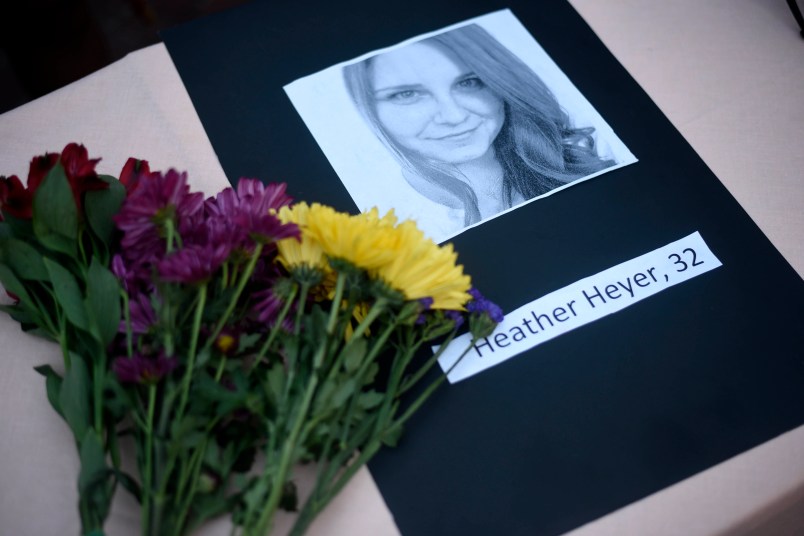 A portrait of Heather Heyer, who was killed when a vehicle drove through counter protestors in Charlottesville, Va., lies on on a table with flowers at the Vigil Against Hate held on the campus of the University of Southern Mississippi in solidarity with the counter protesters killed and injured against the White Nationalists in Charlottesville, Va., in Hattiesburg, Miss. Monday, Aug 14, 2017 (Courtland Wells | Vicksburg Post, via AP)