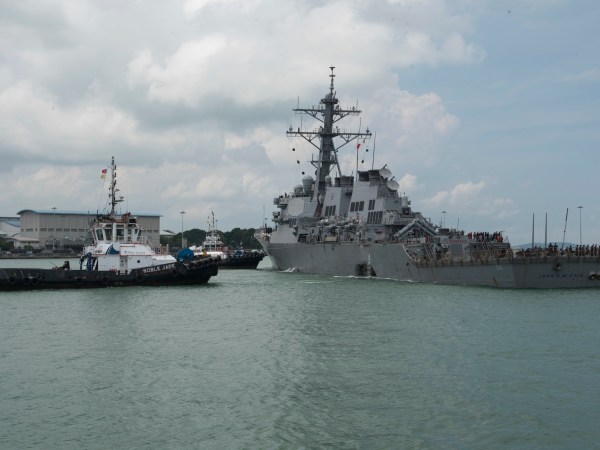 CHANGI NAVAL BASE, REPUBLIC OF SINGAPORE – Tugboats from Singapore assist the Guided-missile destroyer USS John S. McCain (DDG 56) as it steers towards Changi Naval Base, Republic of Singapore following a collision with the merchant vessel Alnic MC while underway east of the Straits of Malacca and Singapore on Aug. 21. Significant damage to the hull resulted in flooding to nearby compartments, including crew berthing, machinery, and communications rooms. Damage control efforts by the crew halted further flooding. The incident will be investigated. (U.S. Navy photo by Mass Communication Specialist 2nd Class Joshua Fulton/Released)