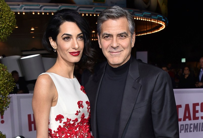FILE - In this Feb. 1, 2016, file photo, Amal Clooney, left, and George Clooney arrive at the world premiere of "Hail, Caesar!" in Los Angeles. The couple announced Tuesday, Aug. 22, 2017, that their Clooney Foundation for Justice is supporting the Southern Poverty Law Center with a $1 million grant to combat hate groups in the United States. (Photo by Jordan Strauss/Invision/AP, File)