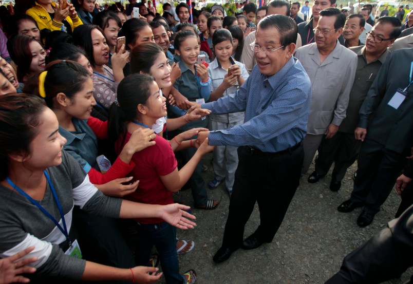 Cambodia's Prime Minister Hun Sen, center, greets garment workers during he takes a visit to Phnom Penh Special Economic Zone at the outskirts of Phnom Penh, Cambodia, Wednesday, Aug. 23, 2017. Hun Sen on Wednesday begun his plan to visit workers who work at the factories in widely Cambodia. (AP Photo/Heng Sinith)