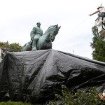 City workers drape a tarp over the statue of Confederate General Robert E. Lee in Emancipation park in Chrlottesville, Va., Wednesday, Aug. 23, 2017.  The move intended to symbolize the city's mourning for a woman killed while protesting a white nationalist rally earlier this month. (AP Photo/Steve Helber)