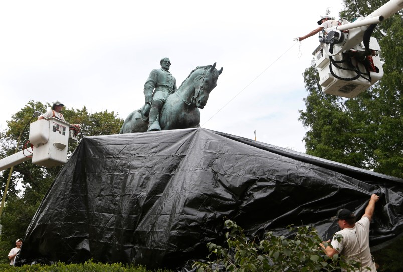 City workers drape a tarp over the statue of Confederate General Robert E. Lee in Emancipation park in Chrlottesville, Va., Wednesday, Aug. 23, 2017.  The move intended to symbolize the city's mourning for a woman killed while protesting a white nationalist rally earlier this month. (AP Photo/Steve Helber)