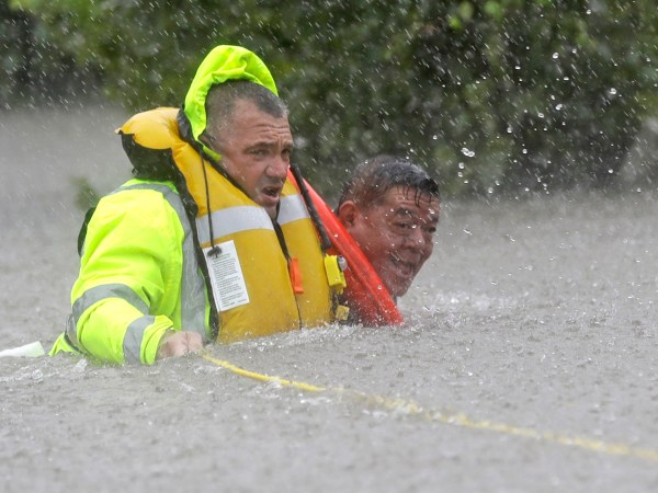 Wilford Martinez, right, is rescued from his flooded car along Interstate 610 in floodwaters from Tropical Storm Harvey Sunday, Aug. 27, 2017, in Houston, Texas. (AP Photo/David J. Phillip)