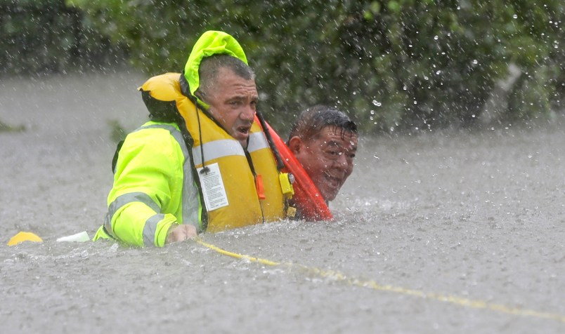 Wilford Martinez, right, is rescued from his flooded car along Interstate 610 in floodwaters from Tropical Storm Harvey Sunday, Aug. 27, 2017, in Houston, Texas. (AP Photo/David J. Phillip)