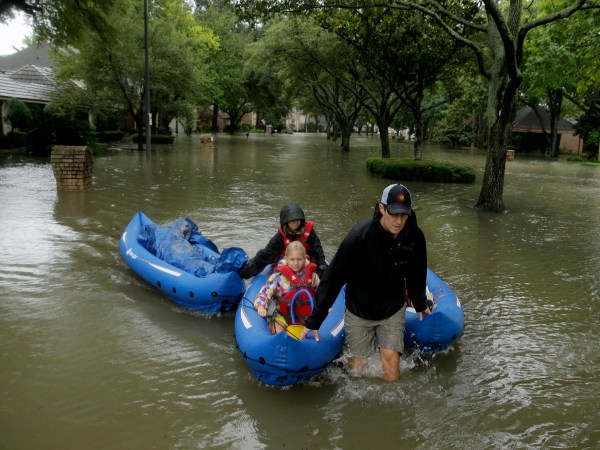 People evacuate a neighborhood in west Houston inundated by floodwaters from Tropical Storm Harvey on Monday, Aug. 28, 2017, in Houston, Texas. (AP Photo/Charlie Riedel)