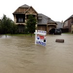 A for sale signs stands in front of a home as floodwaters from Tropical Storm Harvey rise Monday, Aug. 28, 2017, in Spring, Texas. (AP Photo/David J. Phillip)