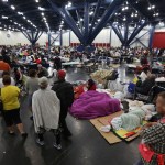 People line up for food and others rest at the George R. Brown Convention Center that has been set up as a shelter for evacuees escaping the floodwaters from Tropical Storm Harvey in Houston, Texas, Tuesday, Aug. 29, 2017. (AP Photo/LM Otero)