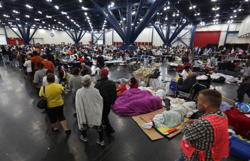 People line up for food and others rest at the George R. Brown Convention Center that has been set up as a shelter for evacuees escaping the floodwaters from Tropical Storm Harvey in Houston, Texas, Tuesday, Aug. 29, 2017. (AP Photo/LM Otero)