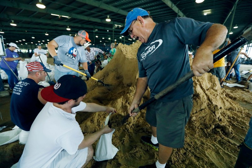Bill Willis, right, and his son, Kyle, join other volunteers to fill sandbags for resident distributions, Tuesday, Aug. 29, 2017, at the Burton Coliseum in Lake Charles, La. (AP Photo/Rogelio V. Solis)