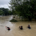 People wade through chest deep water down Pine Cliff Drive as Addicks Reservoir nears capacity due to near constant rain from Tropical Storm Harvey Tuesday, Aug. 29, 2017 in Houston. ( Michael Ciaglo / Houston Chronicle)