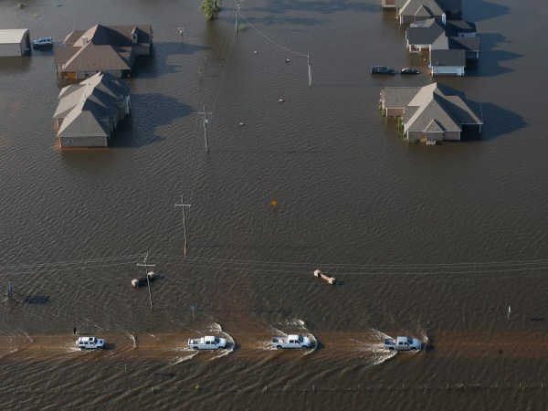 Trucks drive on a flooded rowdy past flooded houses in the aftermath of Tropical Storm Harvey in Orange, Texas, Thursday, Aug. 31, 2017. (AP Photo/Gerald Herbert)