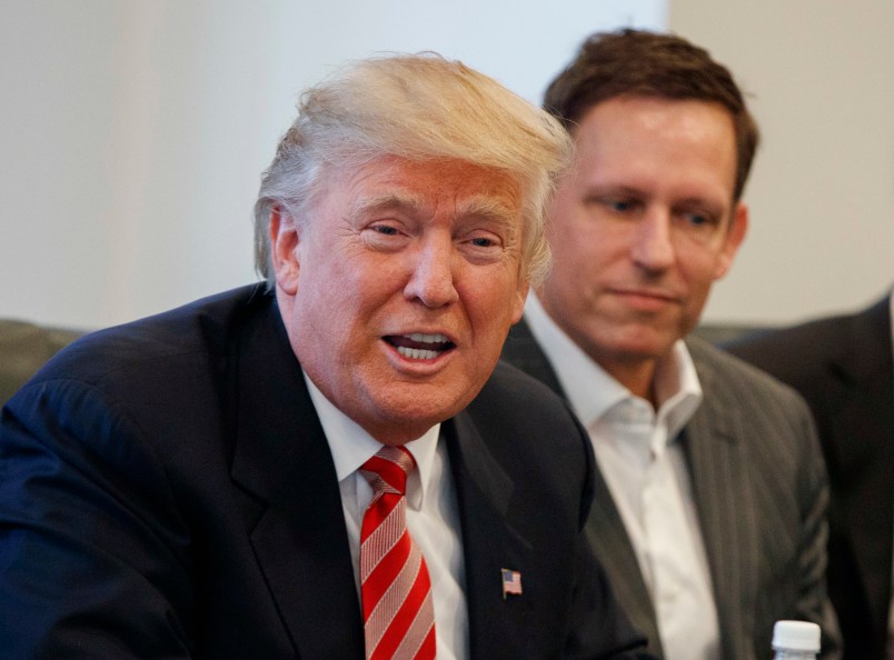 Apple CEO Tim Cook, right, and PayPal founder Peter Thiel, center, listen as President-elect Donald Trump speaks during a meeting with technology industry leaders at Trump Tower in New York, Wednesday, Dec. 14, 2016. (AP Photo/Evan Vucci)