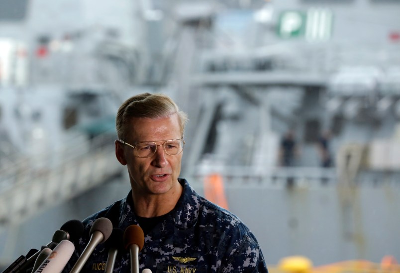 Vice Adm. Joseph Aucoin, Commander, U.S. 7th Fleet, speaks during a press conference with damaged USS Fitzgerald as background at the U.S. Naval base in Yokosuka, southwest of Tokyo Sunday, June 18, 2017. (AP Photo/Eugene Hoshiko)