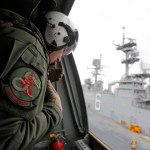 A crewman aboard a U.S. Marine MV-22B Osprey Aircraft looks out as it lifts off the deck of the USS Bonhomme Richard amphibious assault ship off the coast of Sydney, Australia, Thursday, June 29, 2017 after a ceremony on board the ship marking the start of Talisman Saber 2017, a biennial joint military exercise between the United States and Australia. (Jason Reed/Pool via AP)
