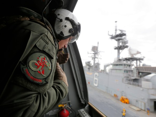 A crewman aboard a U.S. Marine MV-22B Osprey Aircraft looks out as it lifts off the deck of the USS Bonhomme Richard amphibious assault ship off the coast of Sydney, Australia, Thursday, June 29, 2017 after a ceremony on board the ship marking the start of Talisman Saber 2017, a biennial joint military exercise between the United States and Australia. (Jason Reed/Pool via AP)