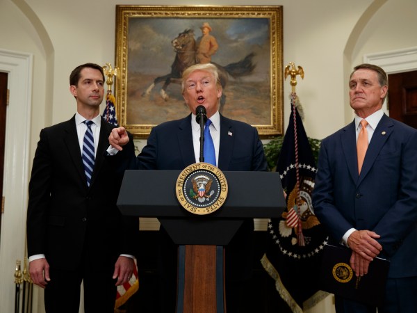 Sen. Tom Cotton, R- Ark., left, and Sen. David Perdue, R-Ga., right, look on as President Donald Trump speaks during the unveiling of legislation that would place new limits on legal immigration, in the Roosevelt Room of the White House, Wednesday, Aug. 2, 2017, in Washington. (AP Photo/Evan Vucci)