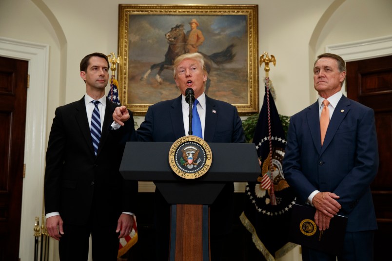 Sen. Tom Cotton, R- Ark., left, and Sen. David Perdue, R-Ga., right, look on as President Donald Trump speaks during the unveiling of legislation that would place new limits on legal immigration, in the Roosevelt Room of the White House, Wednesday, Aug. 2, 2017, in Washington. (AP Photo/Evan Vucci)