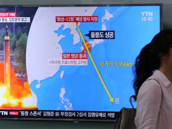 A woman passes by a TV screen showing a local news program reporting on North Korea threatens to strike Guam with ballistic missiles at the Seoul Train Station in Seoul, South Korea, Thursday, Aug. 10, 2017.  North Korea has announced a detailed plan to launch a salvo of ballistic missiles toward the U.S. Pacific territory of Guam, a major military hub and home to U.S. bombers. If carried out, it would be the North’s most provocative missile launch to date. The signs at left top read " North Korea announced a plan to launch a salvo of ballistic missiles toward the Guam. (AP Photo/Ahn Young-Joon)