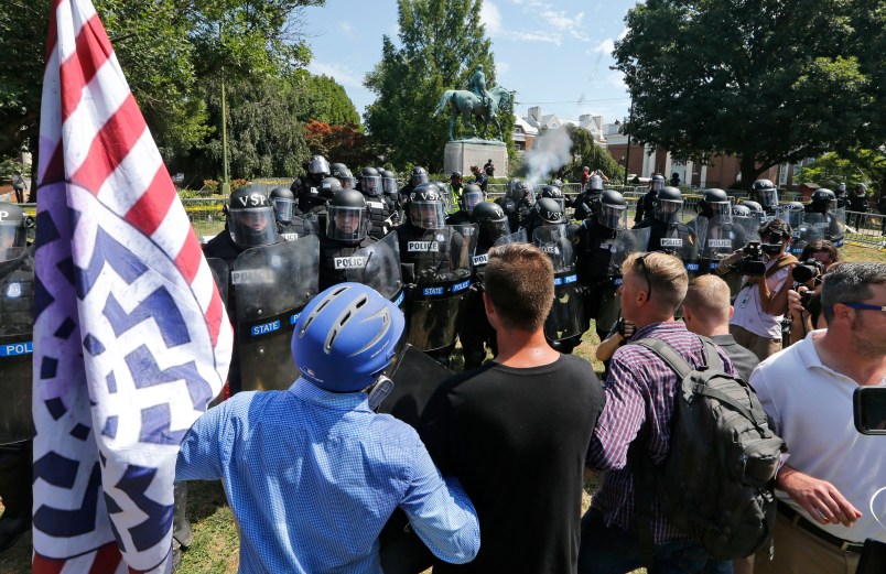 Alt Right demonstrators hold their ground against Virginia State Police as police fire tear gas rounds in Lee Park in Charlottesville, Va., Saturday, Aug. 12, 2017.  (AP Photo/Steve Helber)