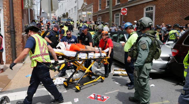 Rescue personnel help injured people after a car ran into a large group of protesters after an Alt Right rally in Charlottesville, Va., Saturday, Aug. 12, 2017.  (AP Photo/Steve Helber)