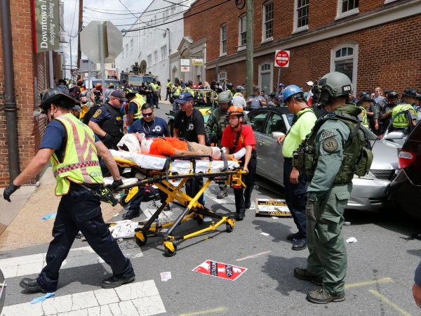 Rescue personnel help injured people after a car ran into a large group of protesters after an Alt Right rally in Charlottesville, Va., Saturday, Aug. 12, 2017.  (AP Photo/Steve Helber)