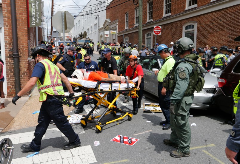 Rescue personnel help injured people after a car ran into a large group of protesters after an Alt Right rally in Charlottesville, Va., Saturday, Aug. 12, 2017.  (AP Photo/Steve Helber)