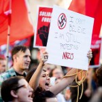 Larisa Roberts joins about one hundred protesters gathered in Oakland, Calif., to show solidarity with victims of a Charlottesville, Va., attack that killed at least one demonstrator against white nationalism on Saturday, Aug. 12, 2017. (AP Photo/Noah Berger)