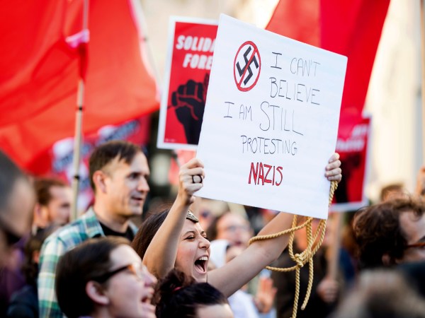Larisa Roberts joins about one hundred protesters gathered in Oakland, Calif., to show solidarity with victims of a Charlottesville, Va., attack that killed at least one demonstrator against white nationalism on Saturday, Aug. 12, 2017. (AP Photo/Noah Berger)
