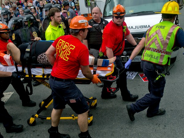 A person is taken away by the EMS workers after a car ran into pedestrians during a Unite the Right rally protest over the name change of Lee Park on Saturday Aug. 12, 2017 in Charlottesville