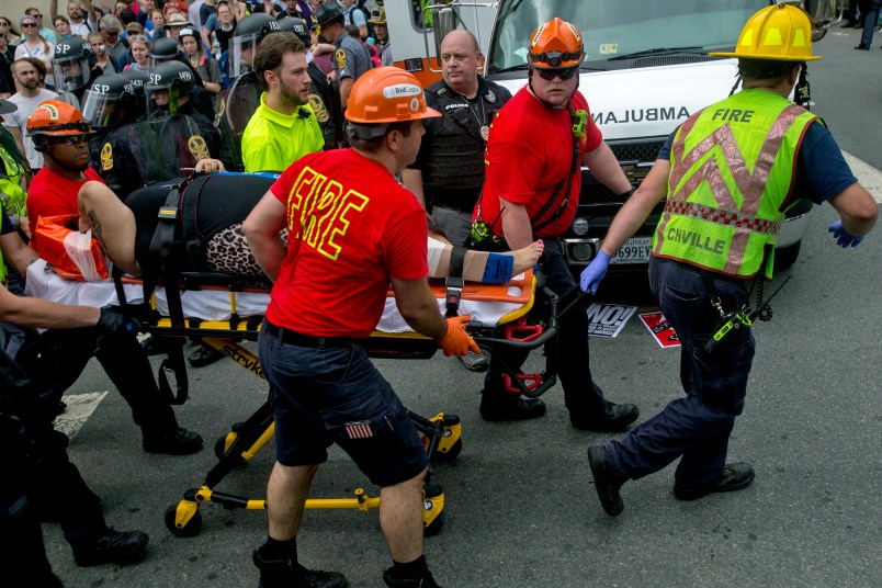 A person is taken away by the EMS workers after a car ran into pedestrians during a Unite the Right rally protest over the name change of Lee Park on Saturday Aug. 12, 2017 in Charlottesville
