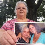 Susan Bro, the mother of Heather Heyer holds a photo of Susan's mother and her daughter, Monday, Aug. 14, 2017, in Charlottesville, Va.  Heyer was killed Saturday, Aug. 12, 2017, when police say a man plowed his car into a group of demonstrators protesting the white nationalist rally. Bro said that she is going to bare her soul to fight for the cause that her daughter died for. (AP Photo/Joshua Replogle)