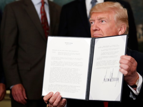 President Donald Trump holds up a signed memorandum calling for a trade investigation of China, in the Diplomatic Reception Room at the White House, Monday, Aug. 14, 2017, in Washington. (AP Photo/Alex Brandon)