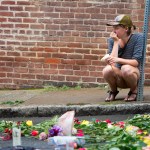 Charlottesville, VA - August 15:  A woman leaves a flower at 4th and Water Streets Tuesday, August 15 in Charlottesville, Va. where Heather Heyer was killed and 19 others were injured when a car intentionally ran through a crowd of counter protestors after the "Unite the Right" rally Saturday. (Photo by Julia Rendleman for The Associated Press)
