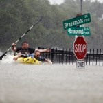 Two kayakers try to beat the current pushing them down an overflowing Brays Bayou along S. Braeswood in Houston, Texas, Sunday, Aug. 27, 2017. Rescuers answered hundreds of calls for help Sunday as floodwaters from the remnants of Hurricane Harvey climbed high enough to begin filling second-story homes, and authorities urged stranded families to seek refuge on their rooftops. (Mark Mulligan/Houston Chronicle via AP)