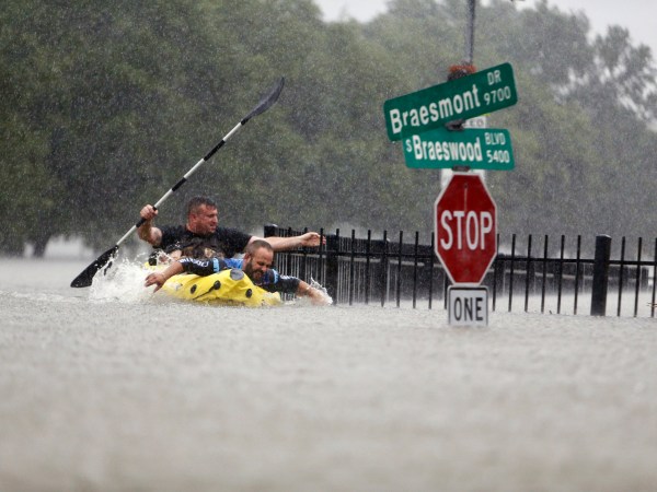 Two kayakers try to beat the current pushing them down an overflowing Brays Bayou along S. Braeswood in Houston, Texas, Sunday, Aug. 27, 2017. Rescuers answered hundreds of calls for help Sunday as floodwaters from the remnants of Hurricane Harvey climbed high enough to begin filling second-story homes, and authorities urged stranded families to seek refuge on their rooftops. (Mark Mulligan/Houston Chronicle via AP)