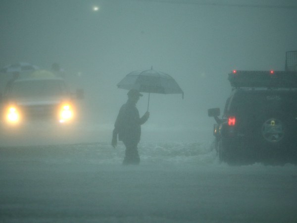 A man walks through floodwaters from Tropical Storm Harvey as he evacuates his home on Sunday, Aug. 27, 2017, in Houston, Texas. (AP Photo/Charlie Riedel)