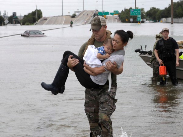 Houston Police SWAT officer Daryl Hudeck carries Connie Pham and her 13-month-old son Aiden after rescuing them from their home surrounded by floodwaters from Tropical Storm Harvey Sunday, Aug. 27, 2017, in Houston, Texas. (AP Photo/David J. Phillip)