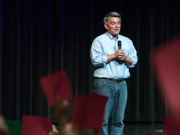 Republican Sen. Cory Gardner of Colorado speaks at a town hall as guests hold red "disagree" and green "agree" cards Tuesday, Aug. 15, 2017, at Pikes Peak Community College in Colorado Springs, Colo.