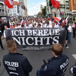 Right-wing extremists walk across the street to commemorate the 30th anniversary of the death of Hitler's deputy Rudolf Hess at the Spandau train station in Berlin, Germany, 19 August 2017. A banner 'Ich bereue Nichts' (lit. I do not regret a thing) can be seen. Hess was convicted as a war criminal and served his sentense at the war criminal prison in Berlin Spandau, where he committed suicide 1987. Four counter demonstrations are also announced. Photo by: Paul Zinken/picture-alliance/dpa/AP Images
