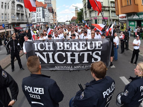 Right-wing extremists walk across the street to commemorate the 30th anniversary of the death of Hitler's deputy Rudolf Hess at the Spandau train station in Berlin, Germany, 19 August 2017. A banner 'Ich bereue Nichts' (lit. I do not regret a thing) can be seen. Hess was convicted as a war criminal and served his sentense at the war criminal prison in Berlin Spandau, where he committed suicide 1987. Four counter demonstrations are also announced. Photo by: Paul Zinken/picture-alliance/dpa/AP Images