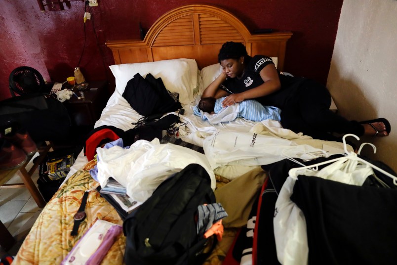 HOLD FOR STORY Jamica Batts sits on a hotel bed with her two-month-old baby Jarasiah Batts as they pack to leave Monday, Sept. 4, 2017, in Houston.  Batts and her brother Alvin may now be forced to go from the hotel they have been staying in, to a area shelter. (AP Photo/Gregory Bull)