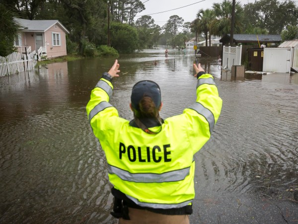 A City of Tybee police officer checks the well being of a resident fleeing her flooded home on Tybee Island, Ga., Monday, Sept., 11, 2017. Parts of the coastal Georgia island suffered storm surge from Tropical Storm Irma. (AP Photo/Stephen B. Morton)