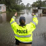 A City of Tybee police officer checks the well being of a resident fleeing her flooded home on Tybee Island, Ga., Monday, Sept., 11, 2017. Parts of the coastal Georgia island suffered storm surge from Tropical Storm Irma. (AP Photo/Stephen B. Morton)