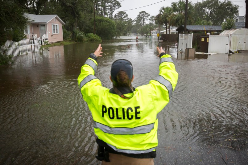 A City of Tybee police officer checks the well being of a resident fleeing her flooded home on Tybee Island, Ga., Monday, Sept., 11, 2017. Parts of the coastal Georgia island suffered storm surge from Tropical Storm Irma. (AP Photo/Stephen B. Morton)