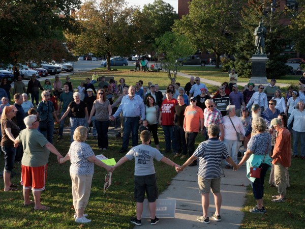 A chorus of "We Shall Overcome" rises from a gathering against racism in Broad Street Park in Claremont, N.H., Tuesday, September 12, 2017. The demonstration was inspired by violence last month against an 8-year-old biracial boy that occurred while he played with a group of teenagers outside his home. (AP Photo/Valley News, James M. Patterson)